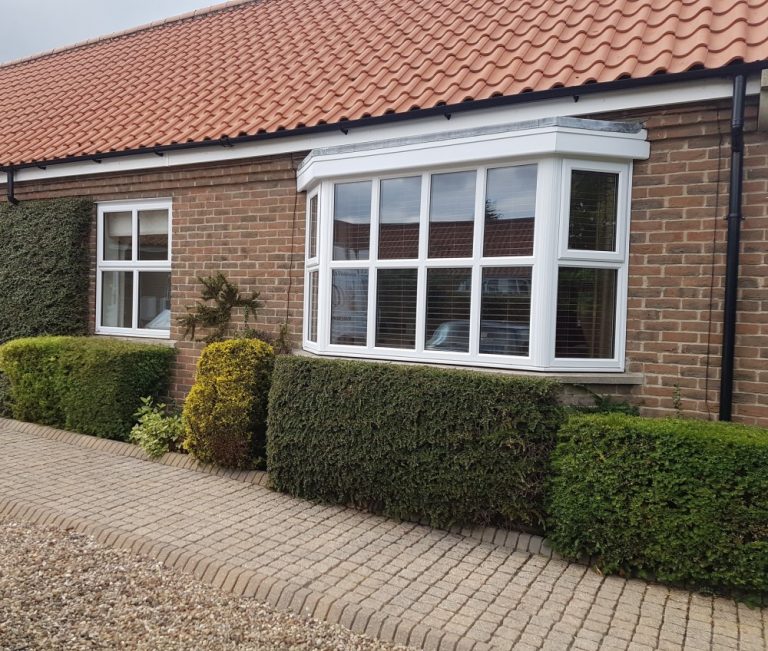new white windows on a red brick bungalow
