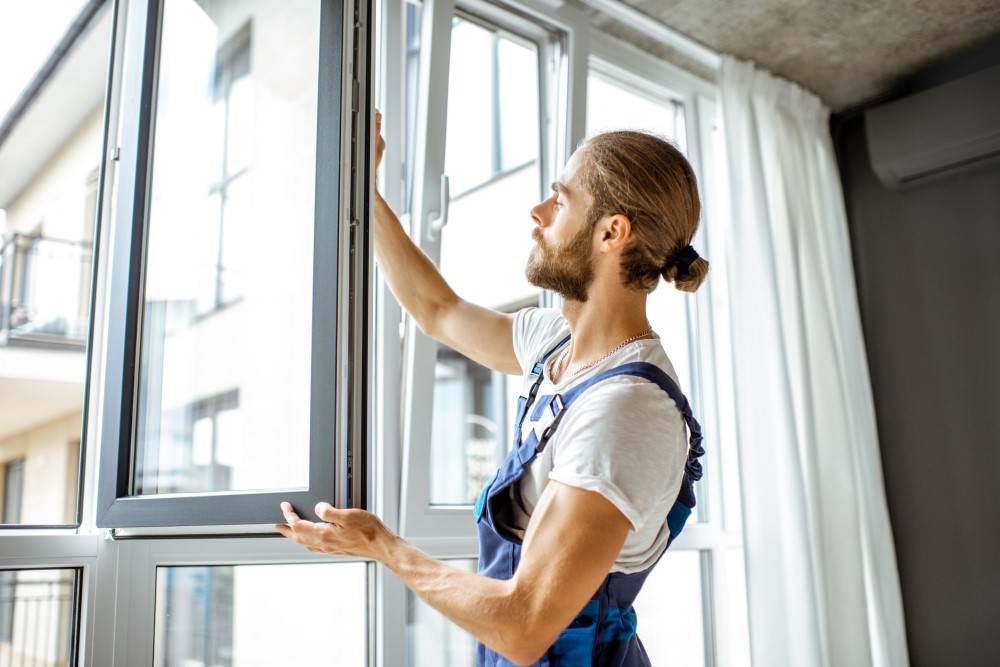 A person who identifies as a man fitting a window.
