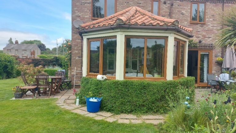 A conservatory with Golden Oak windows and rear additional French doors