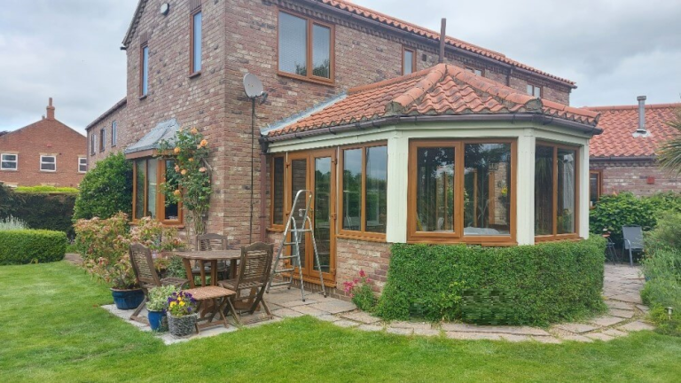 A conservatory with Golden Oak windows and French doors